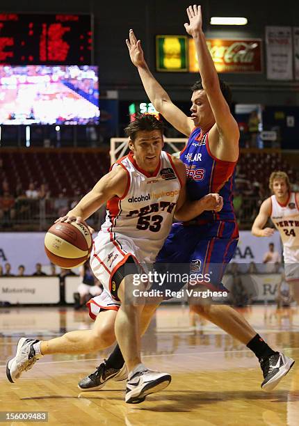 Damian Martin of the Wildcats tries to dribble past Jason Cadee of the 36ers during the round six NBL match between the Adelaide 36ers and the Perth...