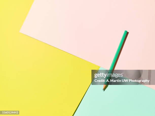 pencil on a geometric pattern coloured background - paper crayons stock pictures, royalty-free photos & images