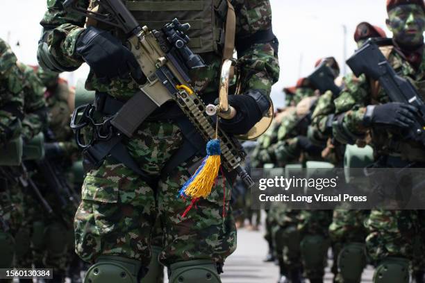 Colombian army soldier holds his rifle and a trumpet during the military parade for the 213 years of Colombia's independence, in Bogota, July 20,...