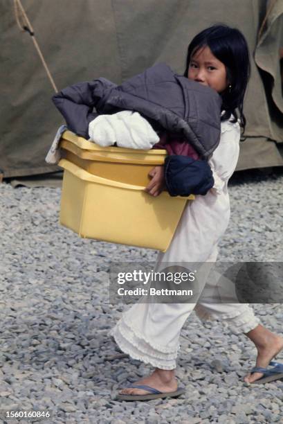 Vietnamese girl carrying laundry at Camp Pendleton in Southern California, June 12th 1975. Camp Pendleton is the first US military base to provide...