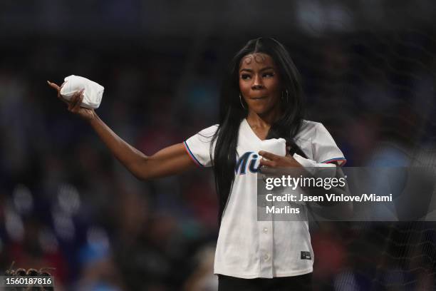 Member of the Miami Marlins Mermaids throws out t-shirts to fans in attendance of the game between the Miami Marlins and the Colorado Rockies at...