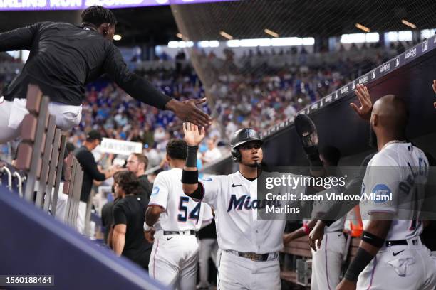 Luis Arraez of the Miami Marlins celebrates with teammates in the dugout after scoring a run in the game Colorado Rockies at loanDepot park on July...