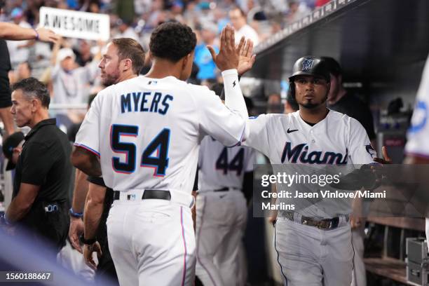 Luis Arraez of the Miami Marlins celebrates with teammates in the dugout after scoring a run in the game Colorado Rockies at loanDepot park on July...