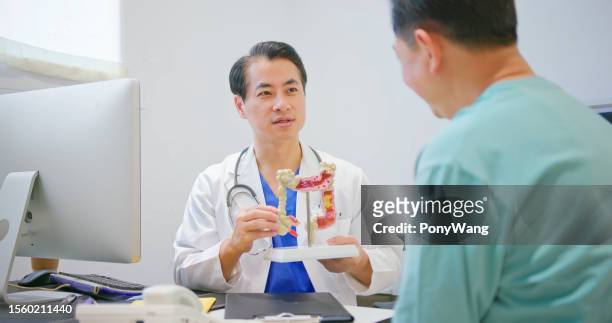 médico mostra modelo de intestino grosso - colonoscopy - fotografias e filmes do acervo