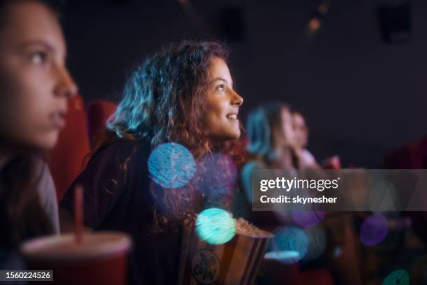 happy little girl enjoying in movie projection at theatre. - children theatre audience stock pictures, royalty-free photos & images