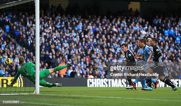 Steven Caulker of Tottenham Hotspur scores the opening goal past Joe Hart of Manchester City during the Barclays Premier League match between...