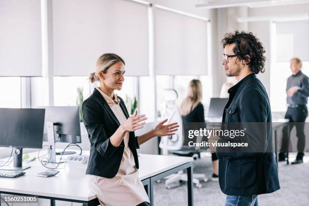 geschäftskollegen, die sich im büro unterhalten - projektmanagement stock-fotos und bilder