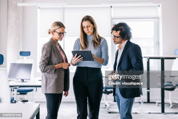 eine kleine gruppe von geschäftsleuten, die unterwegs ein meeting haben - projektmanagement stock-fotos und bilder