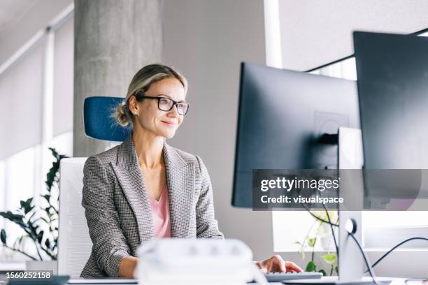 positive businesswoman working at the office - financial advisor stock pictures, royalty-free photos & images