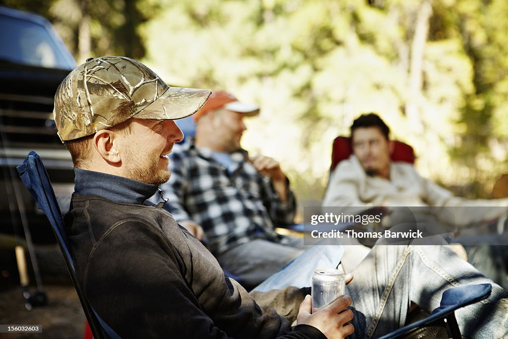 Men sitting at campsite drinking beer