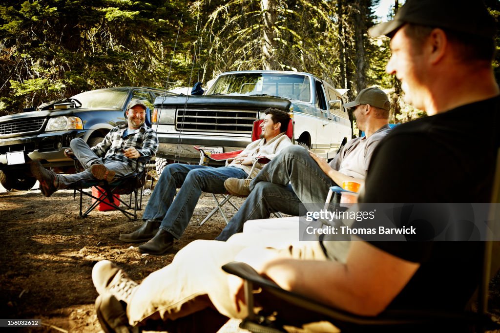 Friends sitting together at hunting camp laughing