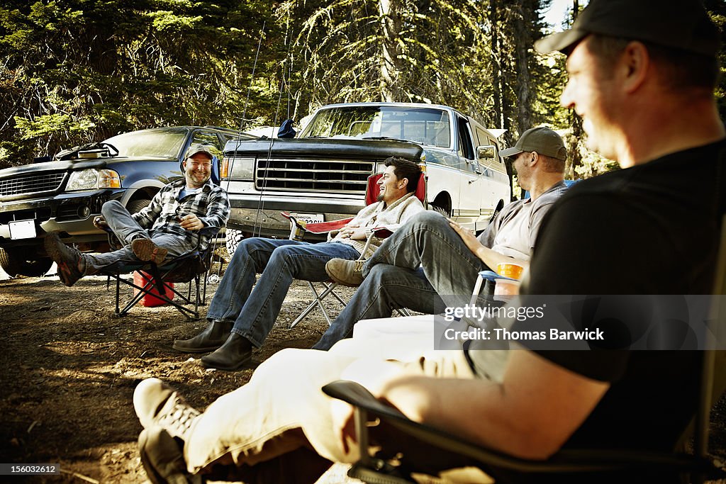 Friends sitting together at hunting camp laughing
