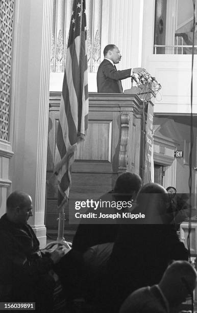 Profile view of American Civil Rights leader Dr. Martin Luther King Jr as he speaks from a lecturn at the New York Avenue Presbyterian Church,...