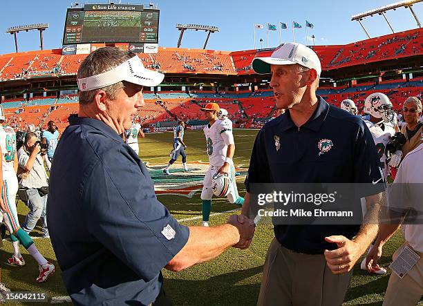 Miami Dolphins head coach Joe Philbin shakes hands with Tennessee Titans head coach Mike Munchak during a game at Sun Life Stadium on November 11,...