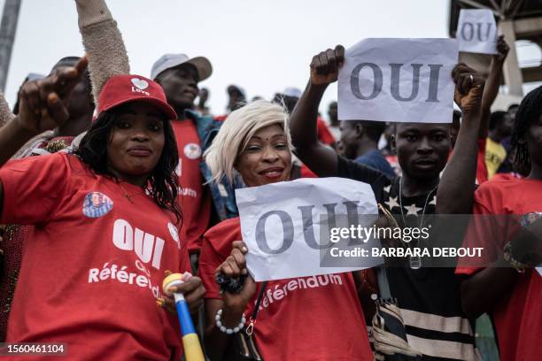 Supporters in favour of amending the constitution hold posters urging to vote yes in the upcoming referendum at the last campaign meeting, in Bangui,...