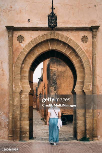 donne che camminano attraverso il cancello nella kasbah degli udayas a rabat, in marocco. - royal tour foto e immagini stock