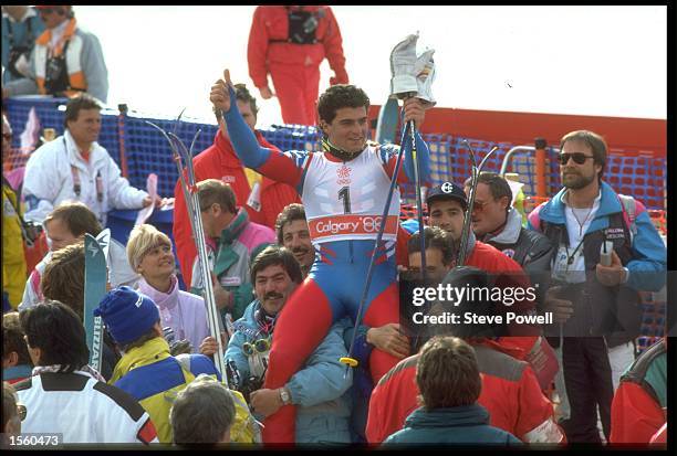 ALBERTO TOMBA OF ITALY BEING CARRIED BY HAPPY SUPPORTERS AFTER WINNING THE GOLD MEDAL IN THE MENS GIANT SLALOM AT THE 1988 CALGARY WINTER OLYMPICS IN...