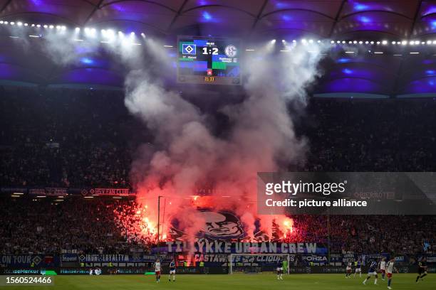July 2023, Hamburg: Soccer: 2nd Bundesliga, Hamburger SV - FC Schalke 04, Matchday 1, at Volksparkstadion. HSV fans set off pyrotechnics. IMPORTANT...
