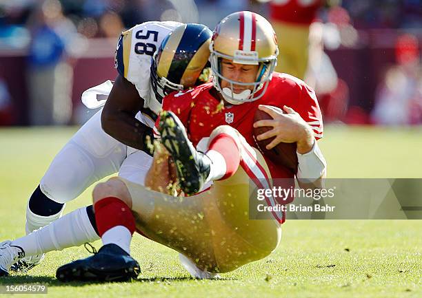 Quarterback Alex Smith of the San Francisco 49ers gets hit by linebacker Jo-Lonn Dunbar of the St. Louis Rams during a run in the first quarter on...