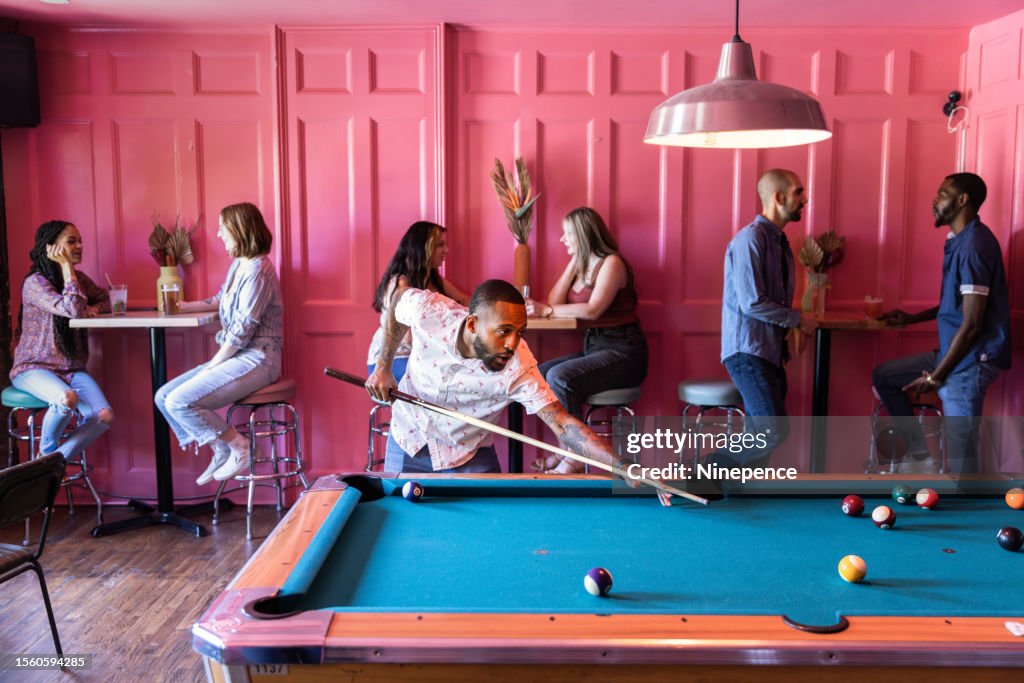 Young man playing pool in a bar