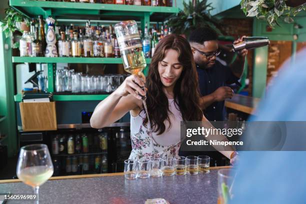 bartender pours a round of shots - barman tequila stockfoto's en -beelden