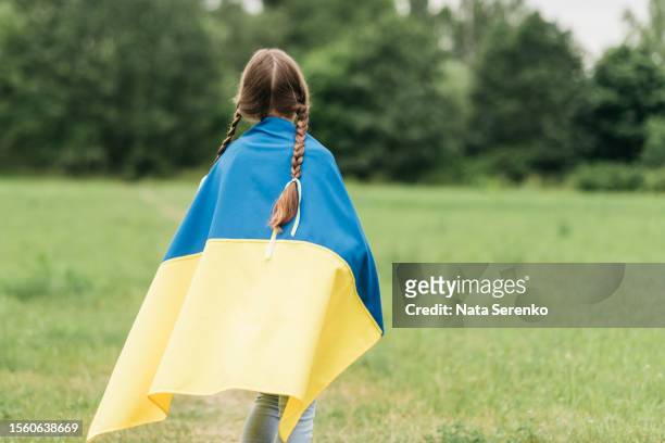 ukrainian child girl in embroidered shirt vyshyvanka with yellow and blue flag of ukraine in garden - maidan nezalezhnosti stock pictures, royalty-free photos & images