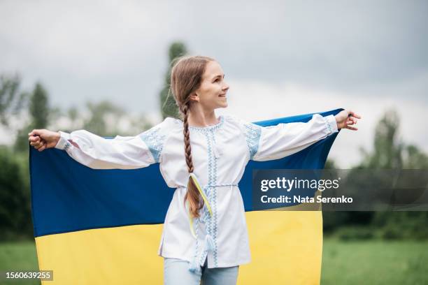 ukrainian child girl in embroidered shirt vyshyvanka with yellow and blue flag of ukraine in garden - maidan nezalezhnosti stock pictures, royalty-free photos & images