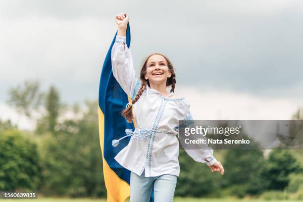 ukrainian child girl in embroidered shirt vyshyvanka with yellow and blue flag of ukraine in garden - maidan nezalezhnosti stock pictures, royalty-free photos & images