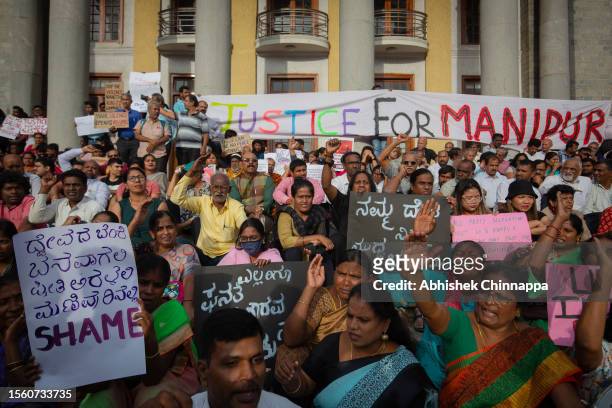 People shout slogans and hold up placards during a protest against violence in the northeastern Indian state of Manipur, on July 21, 2023 in...