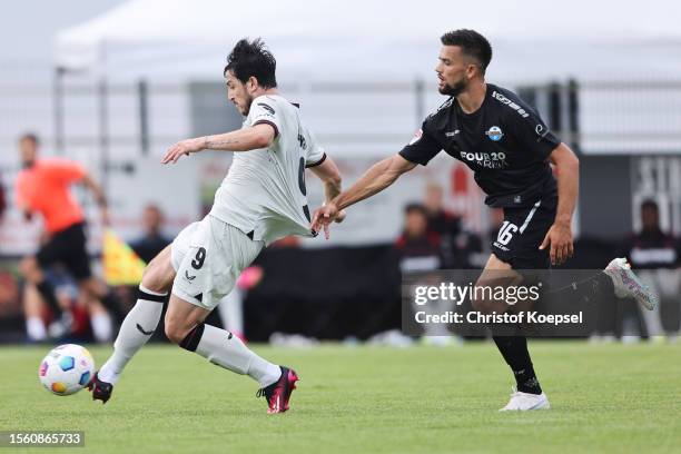 Sardar Azmoun of Leverkusen score the first goal against Visar Musliu of Paderborn during the pre-season friendly match between Bayer 04 Leverkusen...