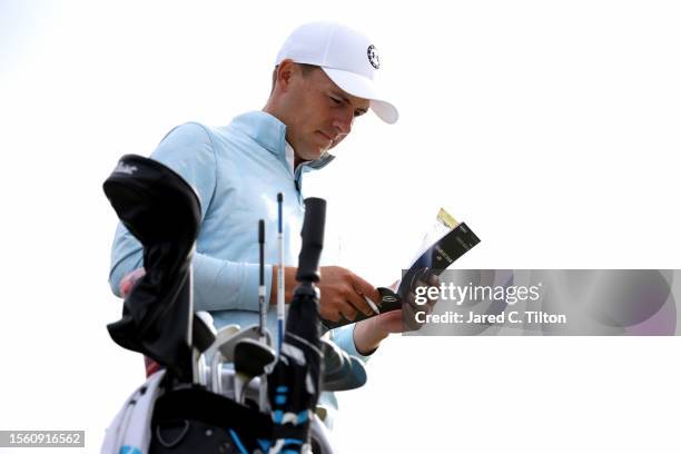 Jordan Spieth of the United States looks at their scorecard and course map before teeing off on the 13th hole on Day Two of The 151st Open at Royal...