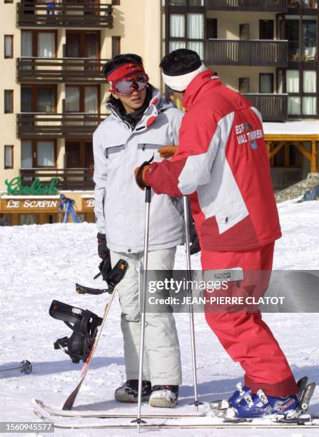 Chinese singer Gao Qi listens to his sky instructor, 20 November 2004 in Val Thorens in the French Alps prior surfing. The Chinese star is to attends...