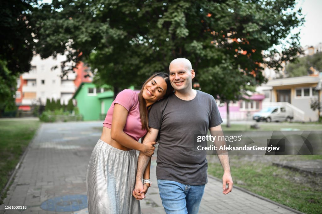 Smiling Male Walking Hand In Hand With Wife After Successfully Defeating Cancer