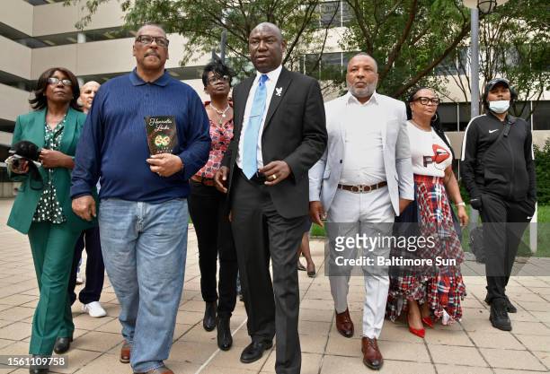 Attorney Ben Crump, middle, surrounded by four grandchildren of Henrietta Lacks and two spouses, head to an October 2021 news conference outside the...