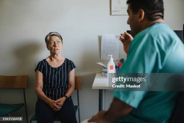 senior woman discussing with male doctor in hospital - sala de exame médico imagens e fotografias de stock