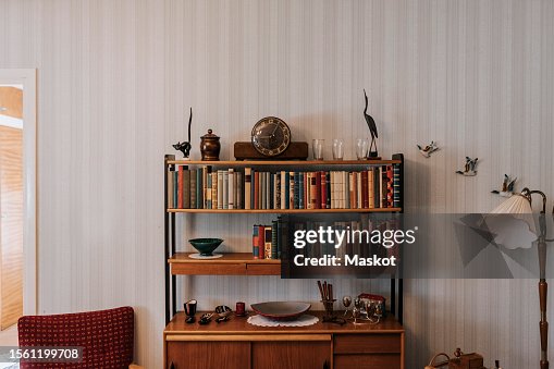 Books and antiques arranged in shelf at home Books and antiques arranged in shelf at home