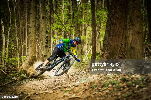 cross-country downhill rider in the forest - mountainbiken stockfoto's en -beelden