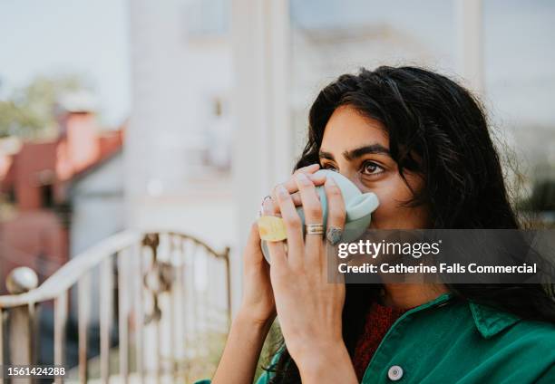 a woman drinks a cup of herbal tea - tea fotografías e imágenes de stock