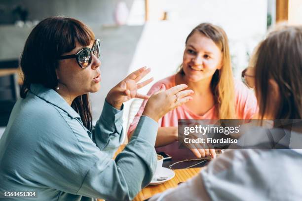 three female friends sitting at table - coffee break party photos et images de collection