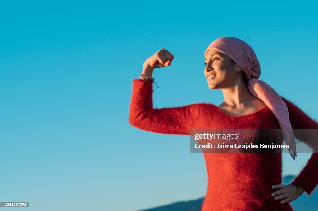 Mujer sana mostrando su puño de poder contra el cáncer femenino