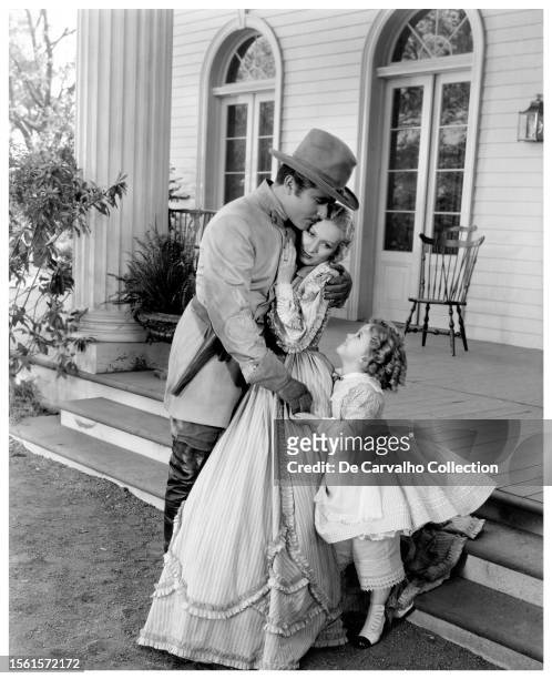 Publicity portrait of actor John Boles , actor Karen Morley , and child actor Shirley Temple in the film 'The Littlest Rebel' United States.