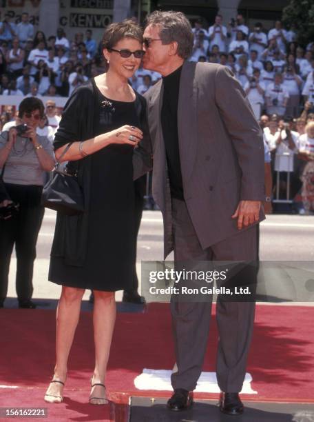 Actress Annette Bening and actor Warren Beatty attend Warren Beatty's hand and footprints in cement on May 21, 1998 at Mann's Chinese Theatre in...