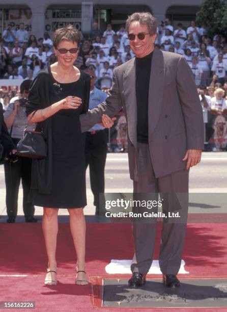 Actress Annette Bening and actor Warren Beatty attend Warren Beatty's hand and footprints in cement on May 21, 1998 at Mann's Chinese Theatre in...