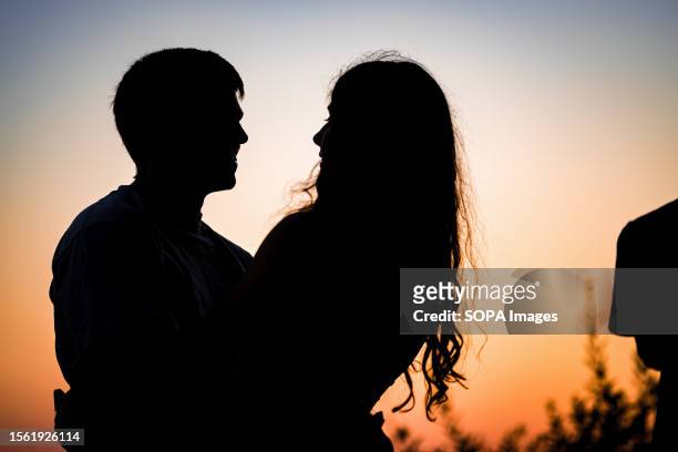 Couple embraces as they enjoy the sunset at Debod Temple.