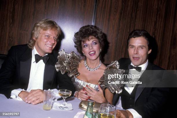 Actress Joan Collins, boyfriend Peter Holm and actor Michael Nader attend the 1983 Carousel of Hope Ball to Benefit the Barbara Davis Center for...