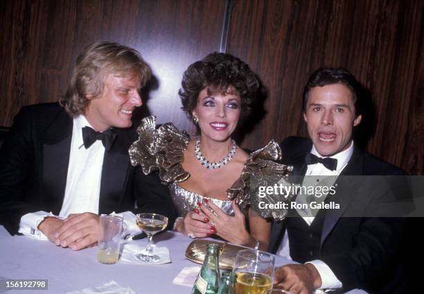 Actress Joan Collins, boyfriend Peter Holm and actor Michael Nader attend the 1983 Carousel of Hope Ball to Benefit the Barbara Davis Center for...