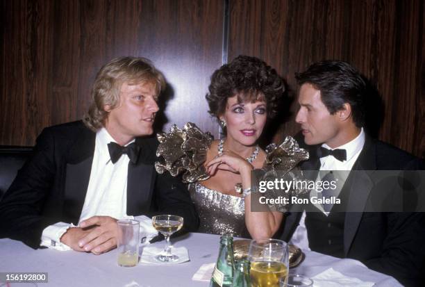 Actress Joan Collins, boyfriend Peter Holm and actor Michael Nader attend the 1983 Carousel of Hope Ball to Benefit the Barbara Davis Center for...