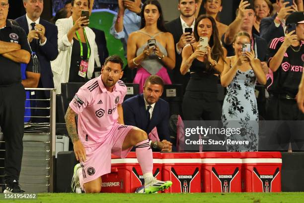 Lionel Messi of Inter Miami CF and co-owner David Beckham look on as fans take photos during the second half of the Leagues Cup 2023 match between...