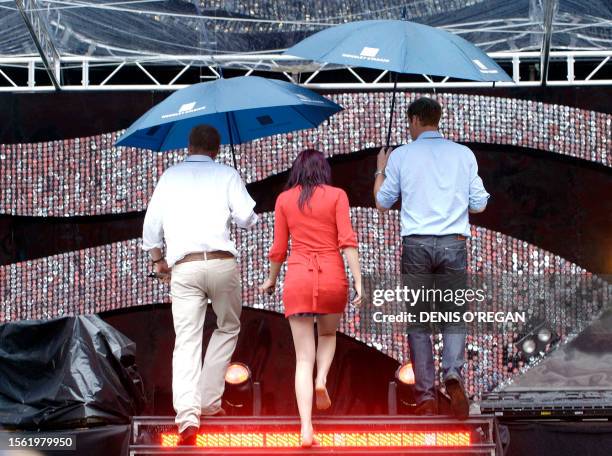 Britain's Prince William , Prince Harry pose and British pop singer Joss Stone walk on the stage of Wembley's Stadium, in London, 30 June 2007. A...