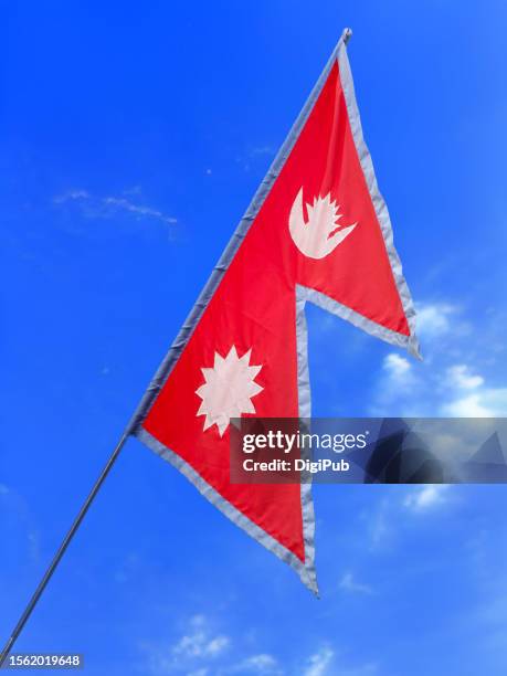 nepali flag isolated against blue sky - nepal flag stock pictures, royalty-free photos & images